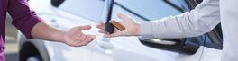 Panorama and close-up of car seller's hand with keys and buyer's hand after transaction Von Photographee.eu
