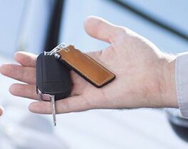Panorama and close-up of car seller's hand with keys and buyer's hand after transaction Von Photographee.eu